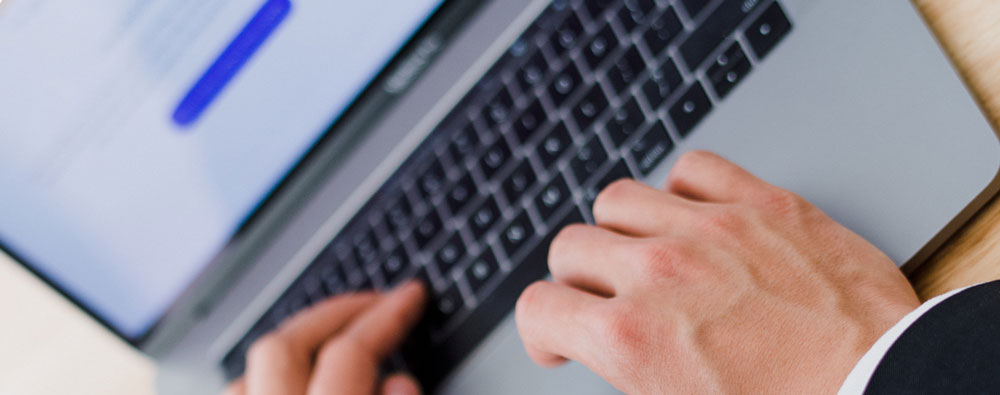 Mans hand on laptop keyboard